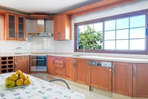 a kitchen with wooden cabinets and a table with fruit on it at Casa Las Cañas in Icod de los Vinos