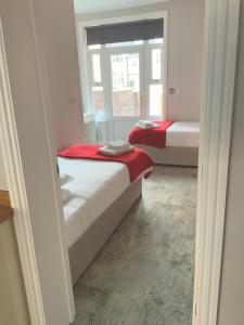 two beds in a small room with a window at 8 Aspland Road in Norwich