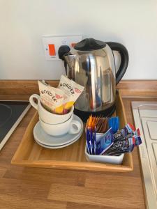 a wooden tray with two cups and a tea kettle at 8 Aspland Road in Norwich