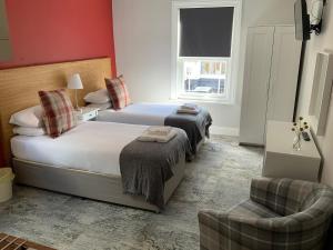 a hotel room with two beds and a chair at 8 Aspland Road in Norwich