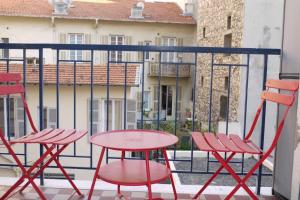 - deux chaises rouges et une table sur un balcon dans l'établissement Dream - a studio flat with balcony at 300m from the beach, à Nice