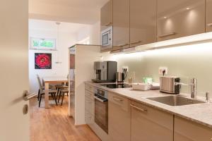 a kitchen with stainless steel appliances and a table at FirstClass Apartments in Hamburg
