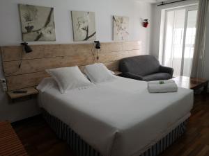 a bed with white sheets and pillows in a room at Hostal Carbonara in A Coruña