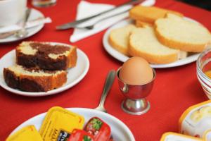 a table with plates of bread and an egg on it at Dioni Hotel in Ioannina