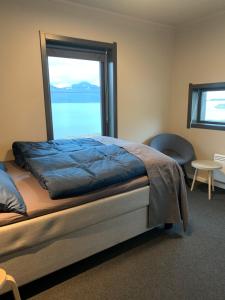 a bedroom with a bed with a large window at BEDEHUSET Basecamp Senja in Skaland