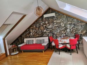 pared de piedra en la sala de estar con sofá y mesa en Apartments Adriatic - Split Stobrec, en Split