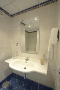 ein Badezimmer mit einem weißen Waschbecken und einem Spiegel in der Unterkunft Festa Panorama Hotel in Nessebar