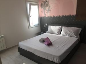 sypialnia z łóżkiem z fioletowym łukiem w obiekcie Altana Deluxe Apart w mieście Chioggia