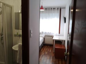 baño pequeño con lavabo y ventana en Hostal Carbonara en A Coruña