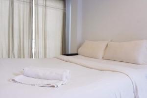 een wit bed met een witte handdoek erop bij Get เกสต์เฮ้าส์ ประชารักษ์ in Hat Yai
