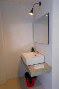 een badkamer met een witte wastafel en een spiegel bij Get เกสต์เฮ้าส์ ประชารักษ์ in Hat Yai
