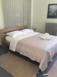 a bedroom with a large bed with white sheets and pillows at Aggelis Traditional Appartment in Sparta