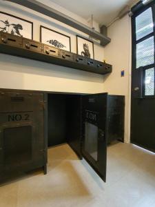 a room with two black cabinets and a shelf on the wall at Roompini in Bangkok