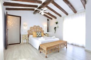 1 dormitorio con cama blanca y techo de madera en Urbanización El Oasis, 20 Villas en 1ª Línea Playa, en Denia