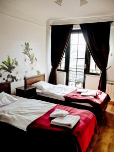 two beds in a bedroom with towels on them at Oberża Złota Gęś in Siewierz