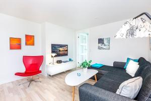 a living room with a couch and a red chair at In the heart of Tórshavn in Tórshavn