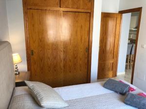 1 dormitorio con 1 cama y puerta de madera en Our Sol, en Puerto de Mazarrón