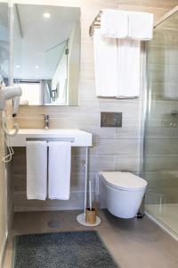 a bathroom with a toilet and a sink and a shower at Lagos Atlantic Hotel in Lagos