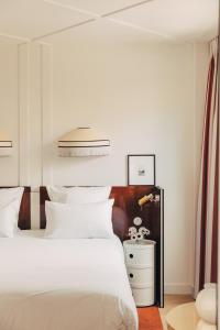 1 dormitorio con cama blanca y mesita de noche blanca en Hôtel Wallace - Orso Hotels en París