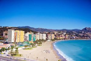 widok na plażę z budynkami i ocean w obiekcie MÁLAGA VELARDE cENTER w Maladze