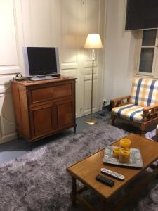 a living room with a television and a coffee table at Aggelis Traditional Appartment in Sparta