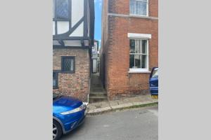 ein blaues Auto, das vor einem Backsteingebäude parkt in der Unterkunft Fisherman's Cottage in Hastings Old Town in Hastings + 2 Fotos