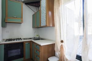 uma cozinha com armários verdes, um lavatório e uma janela em Villa grande piscina spiagge Maldive Salento m350 em Specchia