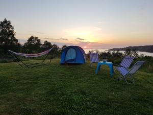 a tent and two chairs and a table in a field at Leite Telt Camping in Lyngstad