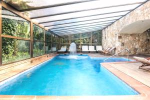 a large swimming pool with a ceiling and windows at Rigat Park & Spa Hotel - Adults Recommended in Lloret de Mar