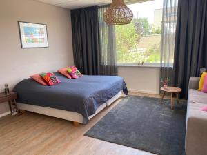 a bedroom with a bed and a large window at Studio Brinkstraat in Hoogeveen