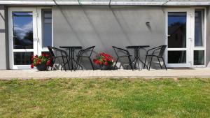 um grupo de cadeiras e mesas em frente a uma casa em Muziejaus 10 studija em Anykščiai