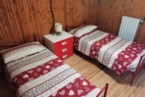 two beds sitting next to each other in a room at La Casa nel Bosco - Your Mountain Holiday in Casargo