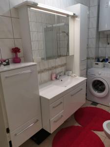 a bathroom with a sink and a washing machine at Apartman Lučica in Zadar