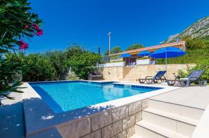 a swimming pool in a villa with a patio at Villa Mateo with Private Pool in Gruda