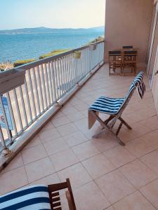 een stoel op een balkon met uitzicht op de oceaan bij Le Latania in Sainte-Maxime
