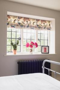a window with a curtain and flowers in a bedroom at Flore House in Flore