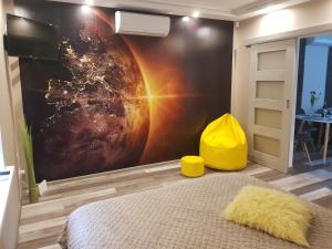 a bedroom with a large wall mural of a planet at zacisze in Jelenia Góra