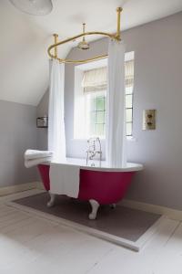 a bathroom with a red bath tub with a window at Flore House in Flore