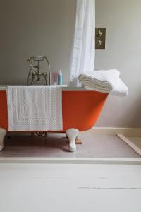 eine orangefarbene Badewanne mit Waschbecken im Bad in der Unterkunft Flore House in Flore