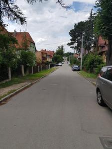 an empty street with cars parked on the side of the road at zacisze in Jelenia Góra