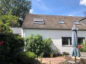 ein weißes Haus mit einem geschlossenen Schirm davor in der Unterkunft Nettes Appartment in Langenhagen in Hannover