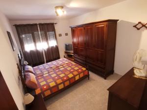 馬塔拉斯卡尼亞斯的住宿－Entre pinos y playa，一间卧室配有一张床和一个木制橱柜