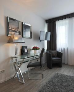 een hotelkamer met een bureau en een stoel bij Boardinghouse Düsseldorf in Düsseldorf