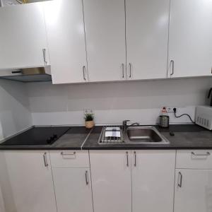 a kitchen with white cabinets and a sink at Luz y Sol San Fernando in San Fernando