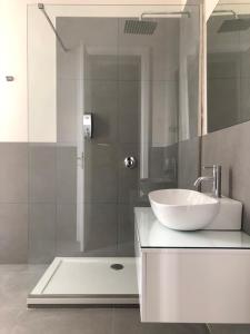 uma casa de banho com um lavatório branco e um chuveiro em Barrique Guest House em Palermo