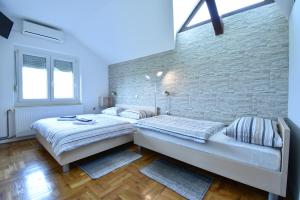 1 dormitorio con 2 camas y pared de ladrillo en Guesthouse Obitelj Paulic, en Slunj