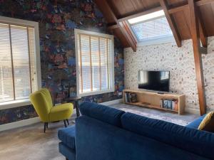 a living room with a blue couch and a television at Slot Oostende in Goes