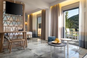 a living room with a television and a living room with a balcony at Notia Luxury Living in Porto Koufo