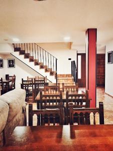 a room with wooden tables and chairs and stairs at De Sol A Sol in Hornillos del Camino