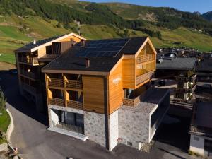 eine Luftansicht eines Hauses mit Sonnenkollektoren auf dem Dach in der Unterkunft Montivas Lodge in Livigno